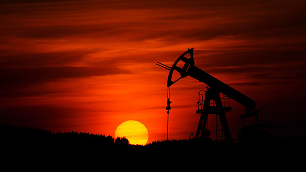 A oil rig at Sunset. Photo by Zbynek Burival on Unsplash