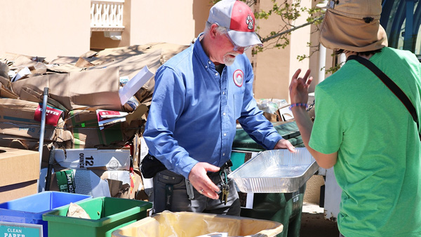 a UNM recycling employee working with recycled materials and bins
